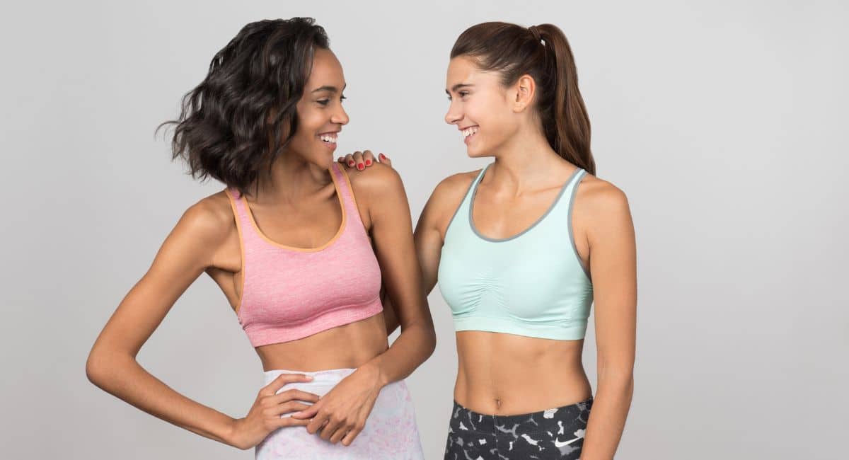 Women in sportswear who are smiling and looking at each other