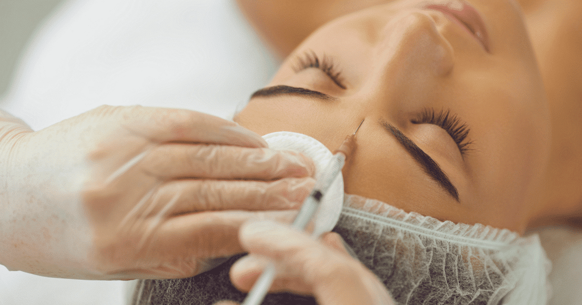 a gorgeous woman's face being treated on her forehead
